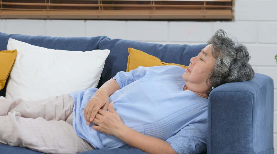 Elderly Woman in blue shirt laying on a blue couch - Dreampad Sound Pillows
